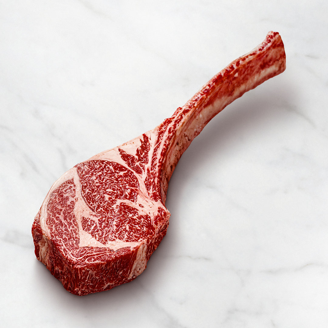 Wagyu Tomahawk Steak mit Knochen auf weißem Hintergrund, intensive Marmorierung, Hochwertiges Fleisch