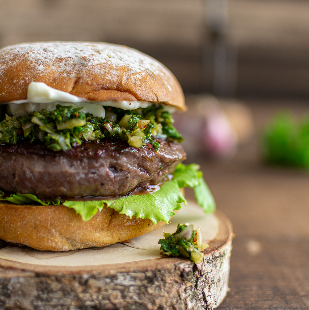 börger-beste, Burger Zubereitung, Wagyu Burger Patty angebraten mit Zwiebeln, Burger Set mit Wagyu-Patties, Burger Set bestellen, Gourmet Wagyu Burger, fertiger Wagyu Burger auf Holzscheibe